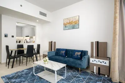 a living room with a blue couch and a table at Elegant 1 Bed Apartment in Binghatti Creek in Dubai