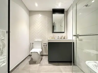 a bathroom with a toilet and a sink and a mirror at Super Spacious 2BR with Designer Touch in Dubai
