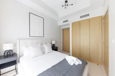 a bedroom with a large white bed and a desk at Cozy 2BR in Business Bay, Aykon Tower in Dubai