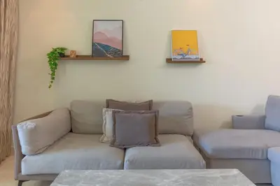 a living room with a couch and a chair at Spacious New 2 BDR, Pool and Beach Access in Dubai