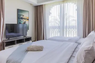 a bedroom with two beds and a flat screen tv at Spacious New 2 BDR, Pool and Beach Access in Dubai