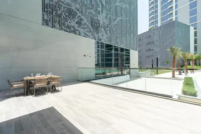 a patio with a table and chairs next to a building at Luxury apartment in Dubai center, District One in Dubai