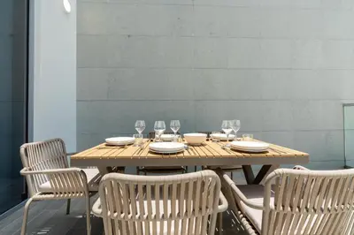 a wooden table with chairs and plates and wine glasses at Luxury apartment in Dubai center, District One in Dubai