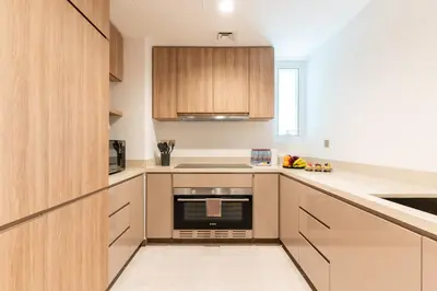 a kitchen with white counters and wooden cabinets at DAYF-DAN Missoni Apartment with Private Lift in Business Bay in Dubai