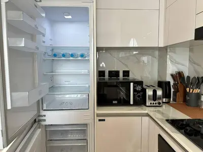 a kitchen with an open refrigerator with a microwave at Gorgeous 1br Apt In Jvc in Dubai