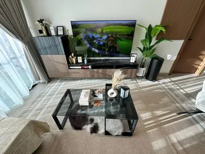 a living room with a glass coffee table and a tv at Gorgeous 1br Apt In Jvc in Dubai