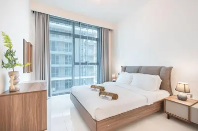 a bedroom with a large bed and a large window at Stunning Beachfront Home with Panoramic Sea Views in Dubai
