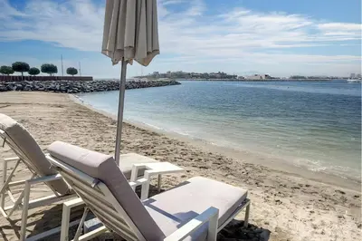 two chairs and an umbrella on a beach at Stunning Beachfront Home with Panoramic Sea Views in Dubai