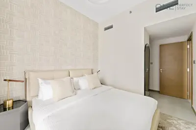 a white bedroom with a white bed and a door at Stylish 2BR in Business Bay canal View Pool & Gym in Dubai