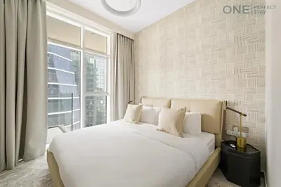 a bedroom with a white bed and a large window at Stylish 2BR in Business Bay canal View Pool & Gym in Dubai