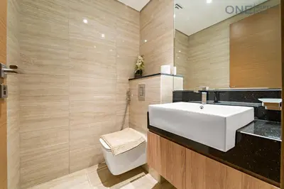 a bathroom with a white sink and a toilet at Stylish 2BR in Business Bay canal View Pool & Gym in Dubai