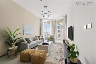 a living room with a couch and a tv at Stylish 2BR in Business Bay canal View Pool & Gym in Dubai