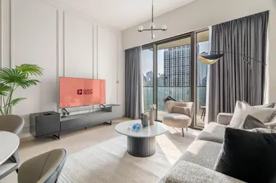a living room with a couch and a tv at GuestReady - Burj Khalifa View l Infinity Pool in Dubai