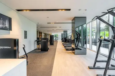 a gym with treadmills and exercise equipment and windows at GuestReady - Burj Khalifa View l Infinity Pool in Dubai