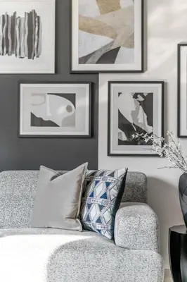 a living room with a couch and pictures on the wall at GuestReady - Burj Khalifa View l Infinity Pool in Dubai
