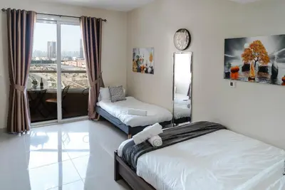 a hotel room with two beds and a window at Studio in Dubai Pool, Gym & Stunning Views in Dubai