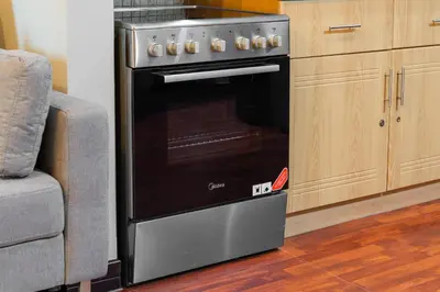 a kitchen oven with an open door next to a chair at Luxury JLT Studio Lake View Metro & Marina in Dubai