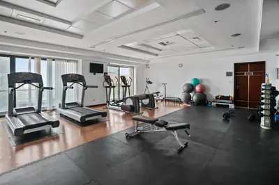 a gym with several treadmills and machines in a room at Luxury JLT Studio Lake View Metro & Marina in Dubai