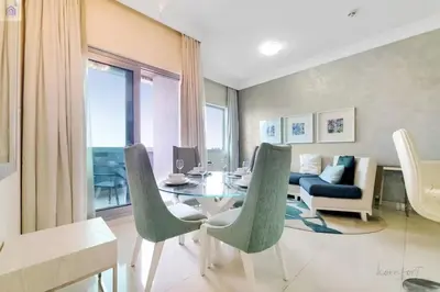 a living room with a glass table and chairs at Luxury Downtown Dubai Stay Next to Mall of Dubai in Dubai