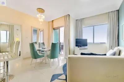 a living room with a table and green chairs at Luxury Downtown Dubai Stay Next to Mall of Dubai in Dubai