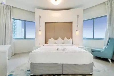 a bedroom with a large bed and a blue chair at Luxury Downtown Dubai Stay Next to Mall of Dubai in Dubai