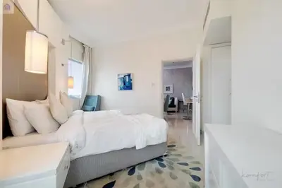 a white bedroom with a large bed and a bathroom at Luxury Downtown Dubai Stay Next to Mall of Dubai in Dubai