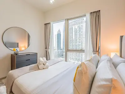 a bedroom with a large bed with a large window at 2 BR - Grande Signature - Burj Khalifa View in Dubai