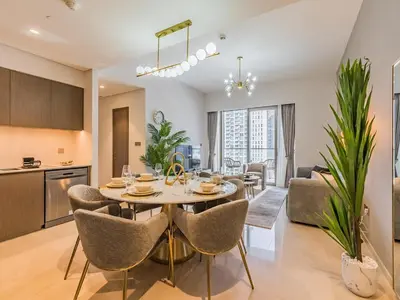 a kitchen and living room with a table and chairs at 2 BR - Grande Signature - Burj Khalifa View in Dubai