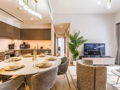a kitchen and dining room with a table and chairs at 2 BR - Grande Signature - Burj Khalifa View in Dubai