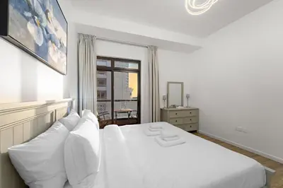 a white bed with white pillows in a bedroom at Elegant 2BR with Seaview in JBR l Walk to the Beach in Dubai