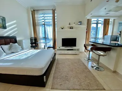 a bedroom with a bed and a flat screen tv at Lovely Studio in Dubai Marina near Beach and Metro Z417 in Dubai