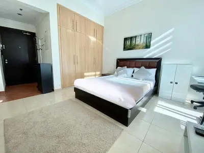 a bedroom with a large bed and a desk at Lovely Studio in Dubai Marina near Beach and Metro Z417 in Dubai