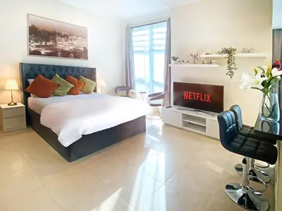 a bedroom with a king sized bed and a television at Elegant Studio in Marina near Beach and Metro Z1113 in Dubai