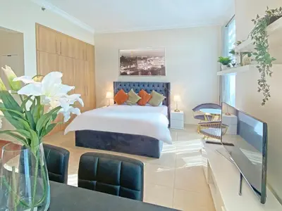 a bedroom with a bed and a table and chairs at Elegant Studio in Marina near Beach and Metro Z1113 in Dubai