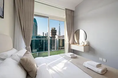 a bedroom with a large window with a view of a city at Exclusive 1-Bedroom Apartment with Breathtaking Burj Khalifa Views in the Heart of Dubai in Dubai