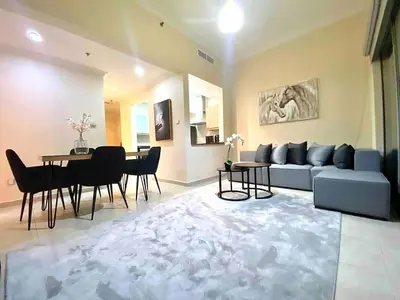 a living room with a blue couch and a table at Cozy 1 Bedroom Apartment with Marina and Sea View Z1306 in Dubai