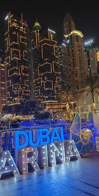 a blue sign in front of a city at night at Private Master Room Marina Beach next to Marriott in Dubai