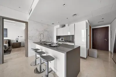 a kitchen with a counter and stools in a room at Luxury Living in Sterling West in Dubai