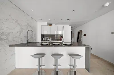 a kitchen with a counter with bar stools at Luxury Living in Sterling West in Dubai