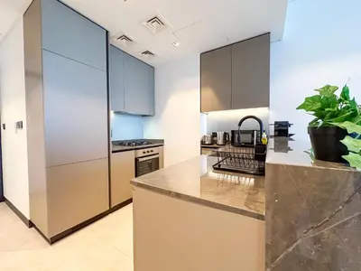 a kitchen with stainless steel appliances and gray cabinets at Luxury 1BR in 15 Northside Tower with Canal View 4AB03 in Dubai