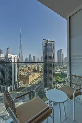 a balcony with chairs and a view of a city at Burj & Beyond - Luxury Stay with Burj Khalifa View in Dubai
