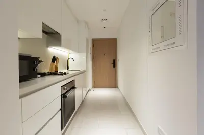 a kitchen with white cabinets and a door to a hallway at Burj & Beyond - Luxury Stay with Burj Khalifa View in Dubai