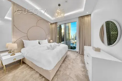 a white bedroom with a large bed and a window at Forte Tower 1 by Emaar - Dubai Fountain View, Downtown Dubai in Dubai