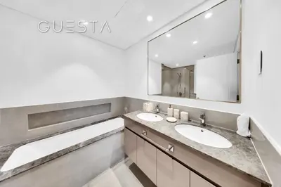 a bathroom with two sinks and a large mirror at Forte Tower 1 by Emaar - Dubai Fountain View, Downtown Dubai in Dubai