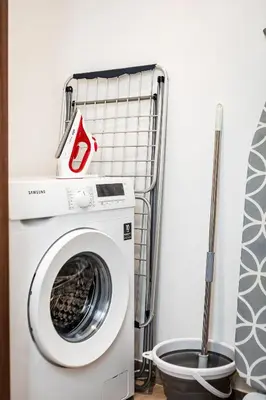 a washer and dryer in a bathroom with a mop at City Walk Green Planet View 1Br in Dubai
