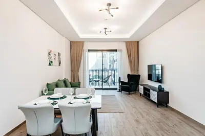 a white living room with a table and chairs at City Walk Green Planet View 1Br in Dubai