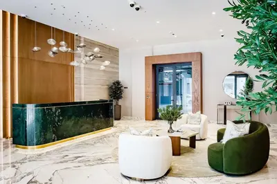 a lobby with a large screen tv and chairs at City Walk Green Planet View 1Br in Dubai