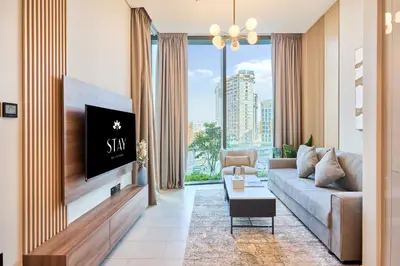a living room with a couch and a tv at STAY BY LATINEM Luxury 1BR Holiday Home W706 Near Burj Khalifa in Dubai