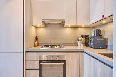 a kitchen with white cabinets and a stove top oven at STAY BY LATINEM Luxury 1BR Holiday Home W706 Near Burj Khalifa in Dubai