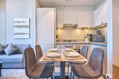 a dining room with a table and chairs in a kitchen at STAY BY LATINEM Luxury 1BR Holiday Home W706 Near Burj Khalifa in Dubai
